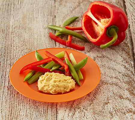 在盘子上放着切成薄片的红辣椒和糖豌豆